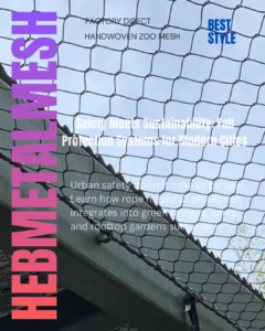 An angled close-up view looking up through a stainless steel cable rope mesh barrier tensioned over an urban walkway, demonstrating a durable and transparent fall protection system with overlays for Hebmetalmesh